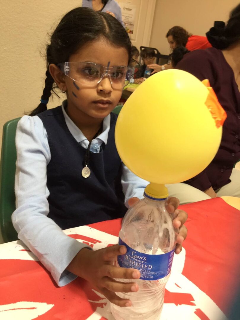 Girls experimenting with balloon and bottle
