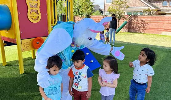 Four kids playing with man wearing elephant's costume